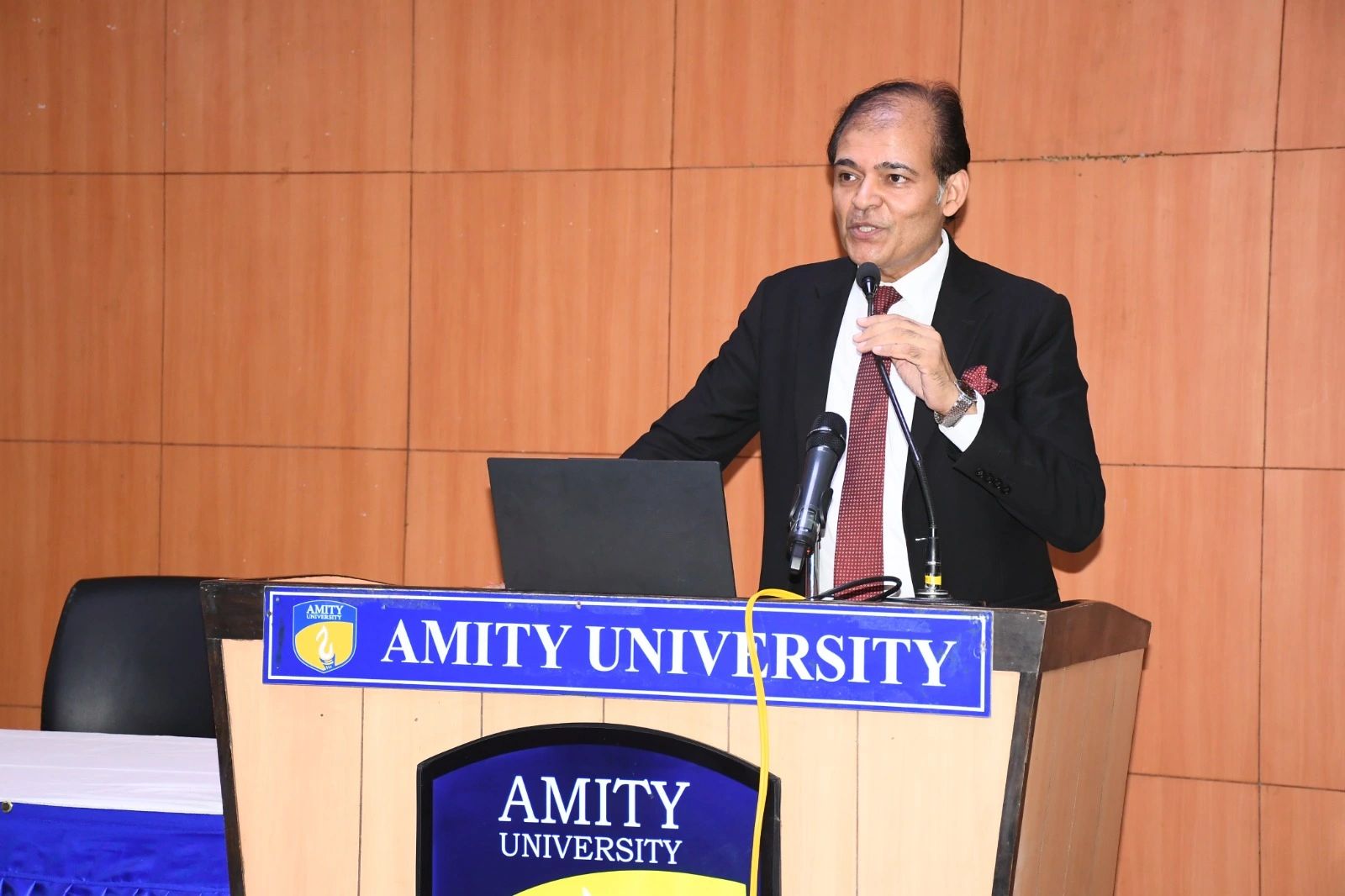 Amity University — Prof. (Dr.) Sanjeev Bansal, Additional Pro Vice Chancellor, addressing delegates from the Amity podium.