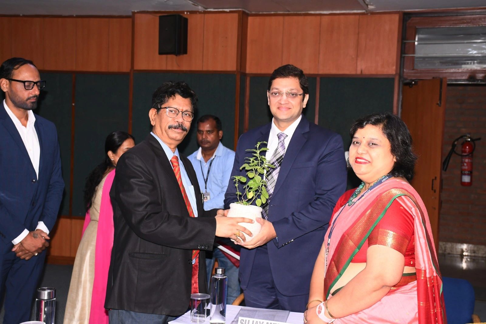 Amity University — Mr. Kapil Kumar receiving the green-commitment Tulsi sapling from Dr. B. K. Murthy and Dr. Garima Agarwal, symbolising the Zero Carbon 2030 mission.